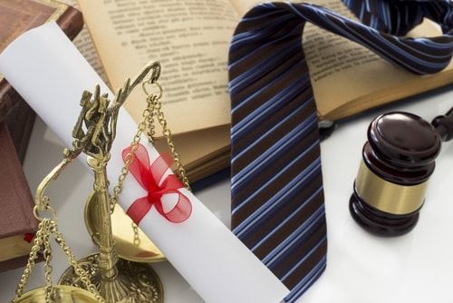 A tie, a gavel and paperwork on a table